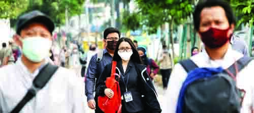 KENAKAN MASKER—Sejumlah warga mengenakan masker di Kawasan Sudirman, Jakarta untuk mencegah penularan Covid-19.