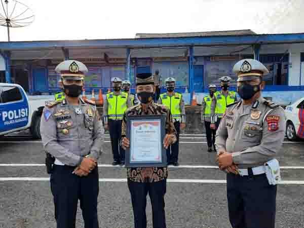 TERIMA PENGHARGAAN— Syafrudin alias Pak Ujang Burung (71), warga Padang Sibusuak, yang juga seorang bantuan polisi (banpol) bertugas mengatur kelancaran lalu lintas dan pengguna jalan secara sukarela, menerima penghargaan dari Polres Sijunjung.
