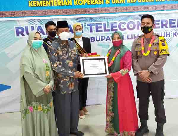 SERAHKAN—Bupati Irfendi Arbi serahkan penghargaan kepada Ketua Bhayangkari Cabang Limapuluh Kota Ny. Maya Trisno Eko