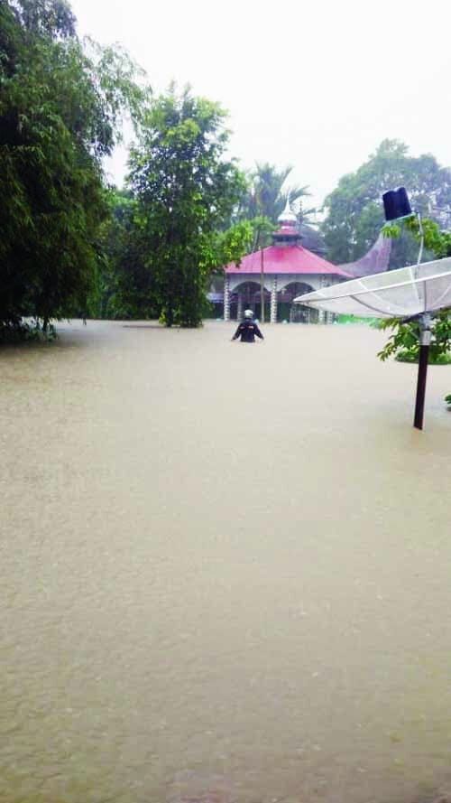 BANJIR— Salah seorang warga berjalan di tengah genangan banjir setinggi sepinggang orang dewasa di Kecamatan Bungus Teluk Kabung. Sementara tim gabungan melakukan pembersihan pohon tumbang di Kecamatan Lubuk Kilangan.