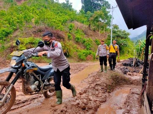 Mendorong--Seorang  personil terpaksa mendorong sepeda motor yang digunakan  Kapolres Pesisir Selatan,  AKBP. Sri Wibowo, yang terjebak lumpur pada saat meninjau lokasi longsor di Kampung Langgai, Nagari Ganting Mudiak Utara Surantih, Kecamatan Sutera, Kabupaten Pesisir Selatan.