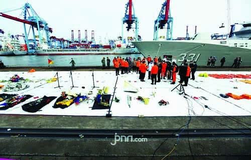 EVAKUASI—Terlihat petugas-mengevakuasi kantong berisi jenazah dan serpihan.