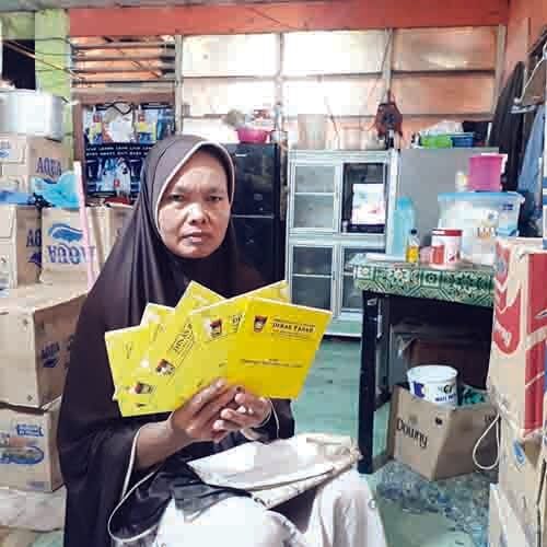 KARTU KUNING-Pedagang eks Inpres I Pasar Raya Padang, Emi (51) memperlihatkan lima kartu kuning yang ia miliki. Sampai saat ini, ia tetap berusaha memperjuangkan haknya kembali.