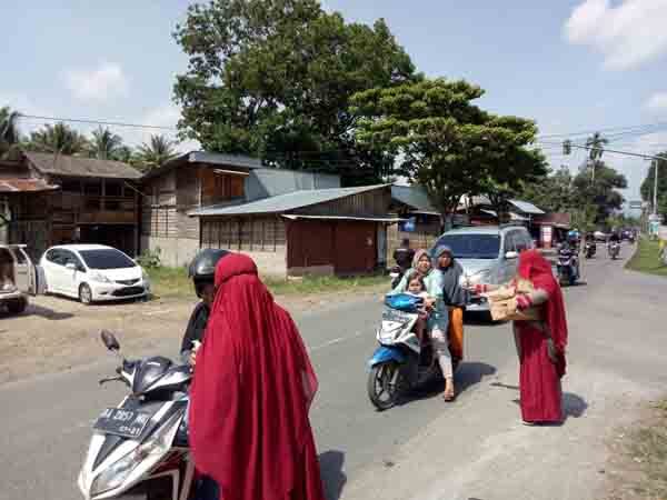 BAGI—Shafiya Community membagikan Ratusan masker dan handsanitizer kepada warga di Pekan Jumat  di Nagari Taeh Baruah Kecamatan Payakumbuh Kabupaten Limapuluh Kota.