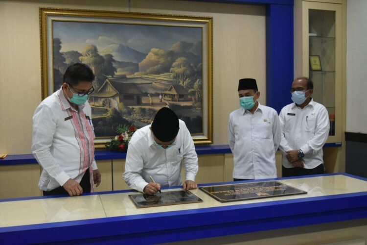 TANDA TANGAN— Bupati Padangpariaman H Ali Mukhni saat menandatangani prasasti dua Puskesmas di dua Kecematan.