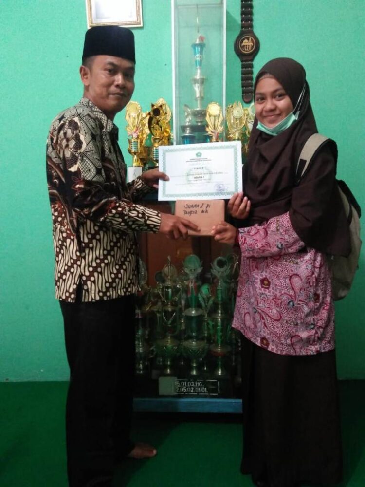 Kepala Sekolah MAN 2 Sijunjung memberikan reward kepada Annisa Nurdin  yang berprestasi dalam menghafal Al-Quran.