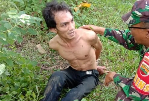 AMANKAN— Serda Damris saat mengamankan orang gila yang meresahkan warga.