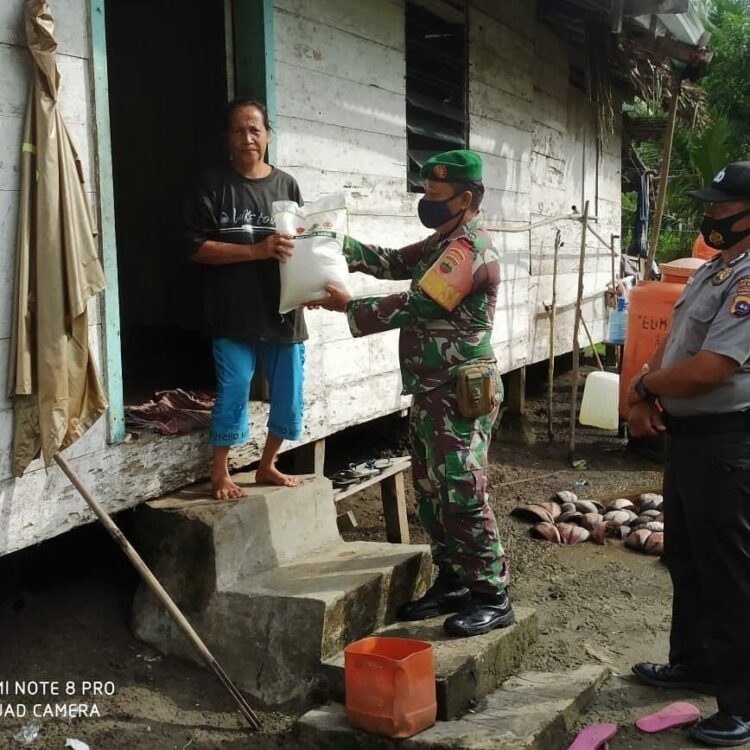 SERAHKAN— Babinsa Koramil 01 Muara Sikabaluan Serda Agus Saut Manurung serahkan bantuan beras.