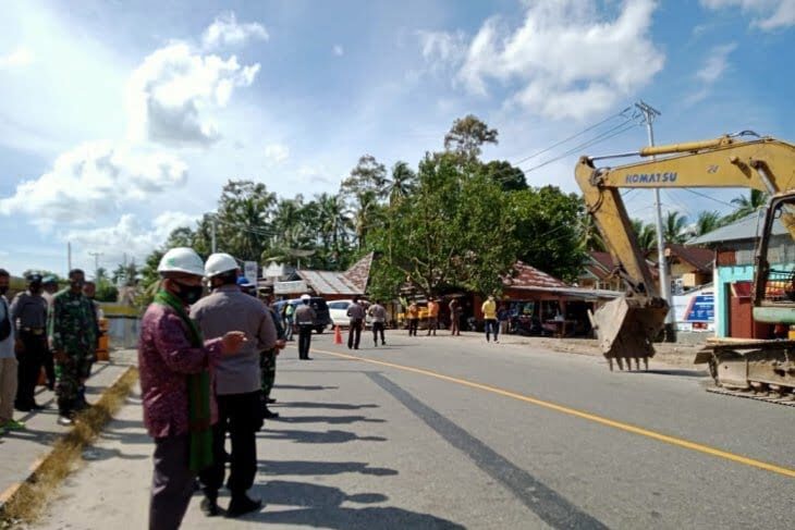 BERJIBAKU—Sejumlah personel Satlantas Polres Padangpariaman berjibaku alihkan kendaraan ke jembatan Titian Kayu di Kayu Tanam.