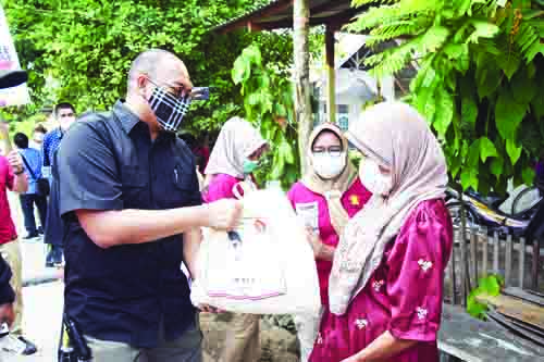SERAHKAN SEMBAKO— Anggota DPR RI Andre Rosiade membagikan sembako untuk warga Banuaran Nan XX, Lubukbegalung, Kota Padang.