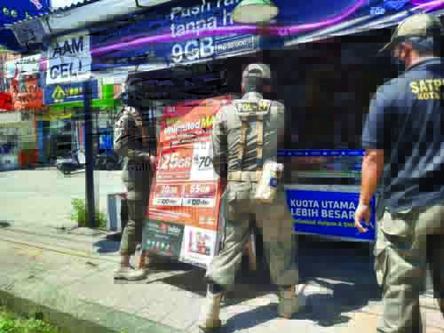 Petugas POl PP sedang melakukan penertiban.