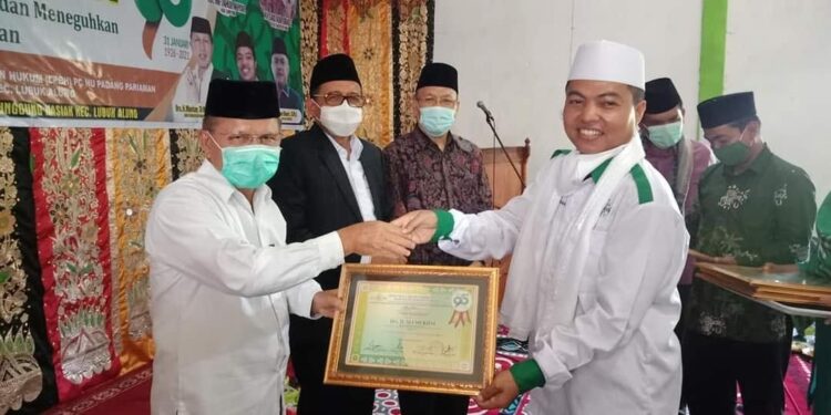 SERAHKAN PENGHARGAAN— Ketua PCNU Padangpariaman H Zainal Tuangku Mudo serahkan penghargaan kepada Bupati Padangpariaman Ali Mukhni sebagai bapak pembangunan.