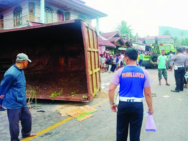 REBAH— Truk tronton rebah kuda usai menabrak dua sepeda motor yang mengakibatkan satu orang tewas dan empat lainnya luka-luka.