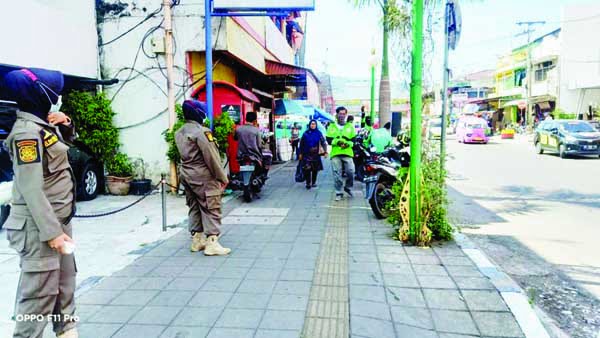 PARKIR LIAR— Tim Praja Wanita Satpol PP Kota Padang memindahkan sepeda motor yang parkir di atas trotoar Permindo. Pemilik sepeda motor juga diminta untuk tidak memarkirkan motornya lagi di trotoar.