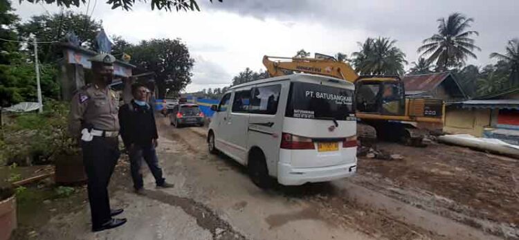 Satu Minggu Ditutup Akibat Dihantam Air Sungai, Jembatan Kelok Pinyaram Dibuka 1 ATUR LALIN—Aipda Endri saat mengatur lalulintas di Jembatan Darurat Kelok Pinyaram.