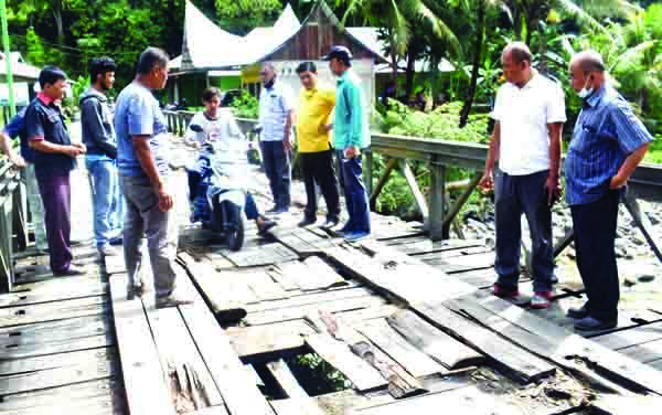 MENINJAU— Anggota DPRD Padang Miswar Jambak meninjau Jembatan Lubuk Sarik, Kecamatan Lubuk Kilangan, yang sudah rusak parah agar segera diperbaiki, Rabu (3/3).