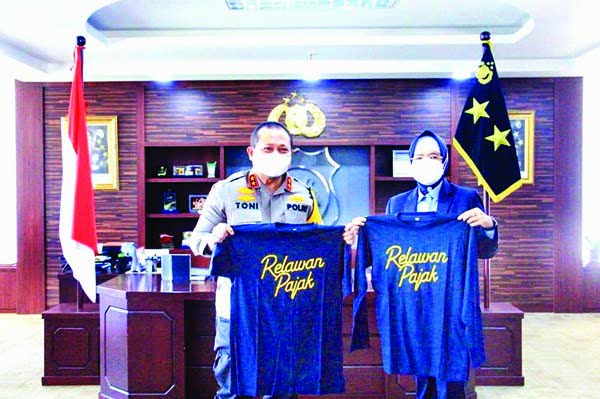 KAOS RELAWAN PAJAK— Kepala Kanwil DJP Sumbarja Lindawaty menyerahkan kaos Relawan Pajak kepada Kapolda Irjen Pol Toni Harmanto, sebagai pertanda bahwa Kapolda Sumbar adalah seorang Relawan Pajak yang secara sukarela telah berperan aktif dalam kegiatan edukasi pajak.