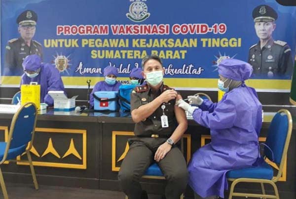 Vaksin— Wakil Kepala Kejaksaan Tinggi Sumbar Yusron divaksin oleh petugas kesehatan, Selasa (16/3).