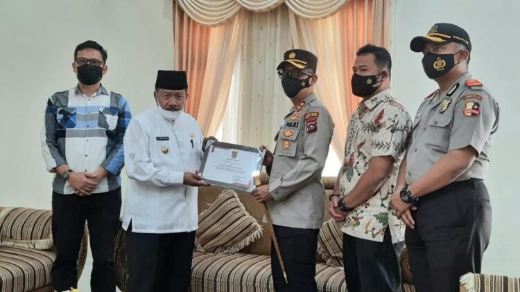 PENGHARGAAN—Bupati Agam Andri Wargam meberikan piagam penghargaan kepada Kapolres Bukittinggi AKBP Dody Prawiranegara, bidang pelayanan publik.