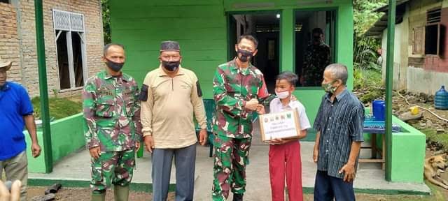 SERAHKAN BANTUAN— Dansatgas TMMD ke - 110 Letkol Czi. Titan Jatmiko didampingi Pasiterdim Lettu Inf. Aidil Adha menyerahkan bantuan.