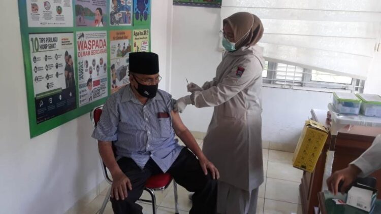 DISUNTIK— Anggota DPRD Padang, Azwar Siry disuntik vaksin, Sabtu (13/3) di Puskesmas Lapai.
