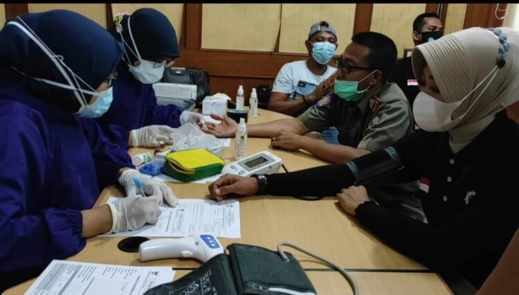 VAKSINASI MASSAL— Personel Satpol PP Kota Padang melakukan vaksinasi di Aula Praja Wibawa Mako Satpol PP, Rabu (17/3).