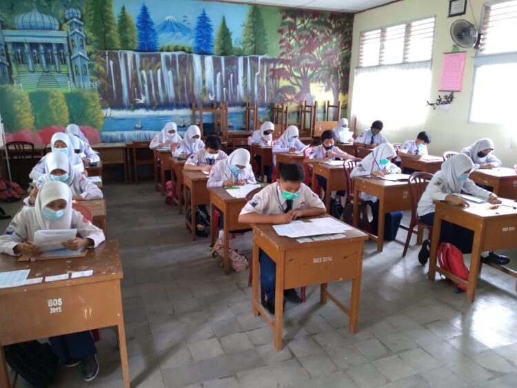 DIBAGI 3 SHIFT— Pelaksanaan UTS di SMP 21 Padang, Senin (23/3) berlangsung lancar. Untuk mencegah penuralan virus corona, penerapan prokes tetap dilakukan dan ujian dibagi 3 shift.