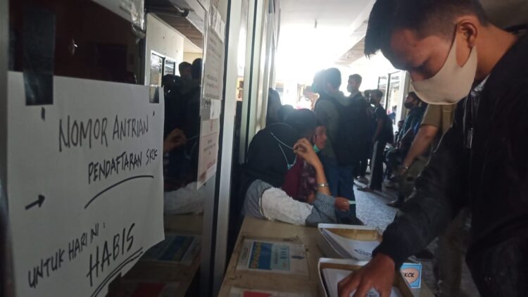 PENGUMUMAN— Petugas loket pengurusan SKCK di Polresta Padang, memasang pengumuman berisi “Nomor antrian pendaftaran SKCK untuk hari ini habis”, Selasa (23/3). Membeludaknya warga mengurus SKCK membuat pihak Polresta melakukan pembatasan untuk mencegah terjadi kerumunan penularan virus corona.