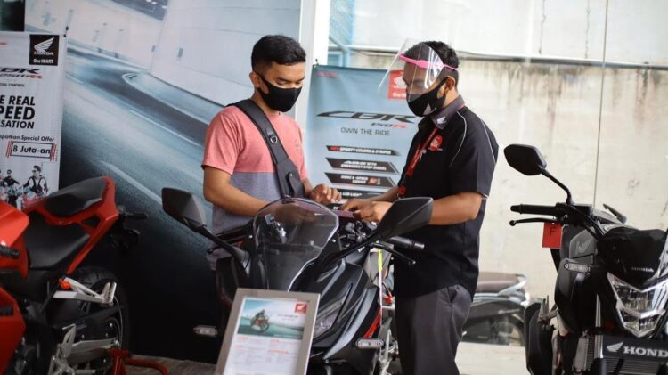 BERIKAN PENJELASAN— Sales marketing PT Menara Agung menjelaskan fitur-fitur serta kelebihan yang disematkan di New Honda CBR150R kepada konsumen.