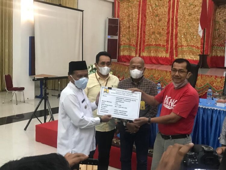 SERAHKAN— Wakil Bupati Padangpariaman Rahmang serahkan ganti rugi untuk pembangunan tol.