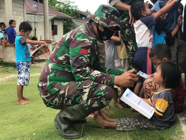 AJAK MEMBACA— Anggota TNI mengajak anak-anak di Mapadeggat, Mentawai.