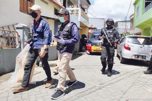 BAWA—Tim Densus 88 membawa bungkusan usai pengeledahan di rumah indekos pelaku bom bunuh diri Gereja Katedral di jalan Tinumbu, Kecamatan Bontoala, Kota Makassar, Sulawesi Selatan, Senin (29/3) lalu.