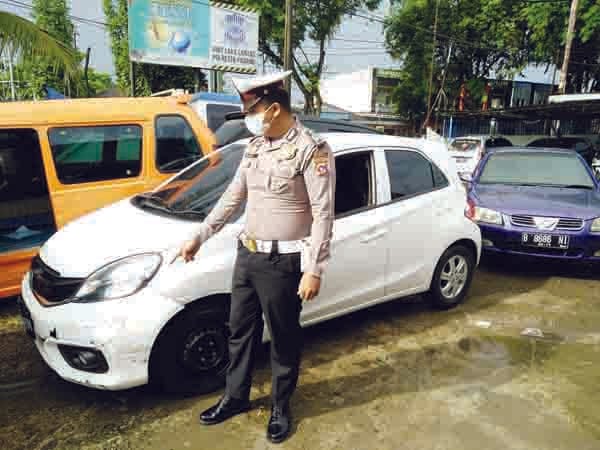 PERLIHATKAN BUKTI— Petugas Unit Laka Lantas Polresta Padang memperlihatkan barang bukti mobil Honda Brio yang menabrak pemotor dan sopirnya dihakimi massa.