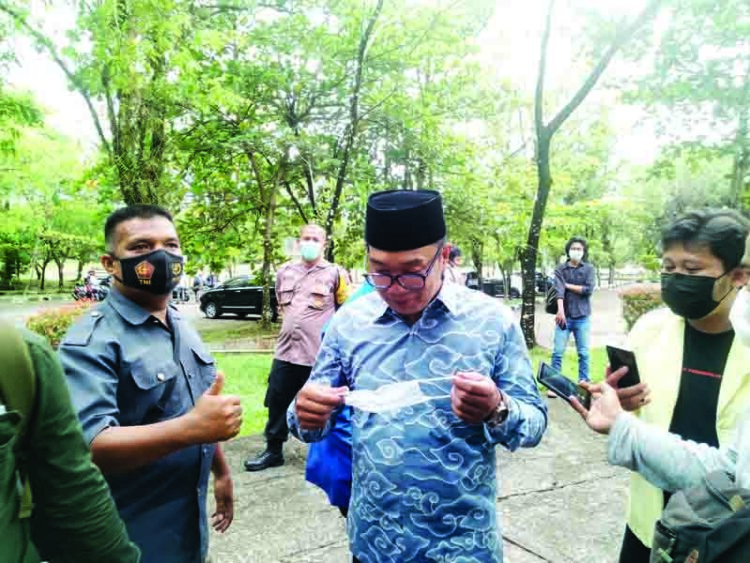 PAKAI MASKER—Gubernur Jawa Barat  Ridwan Kamil saat akan memakasi masker dalam kunjungannya ke Unand kemarin.