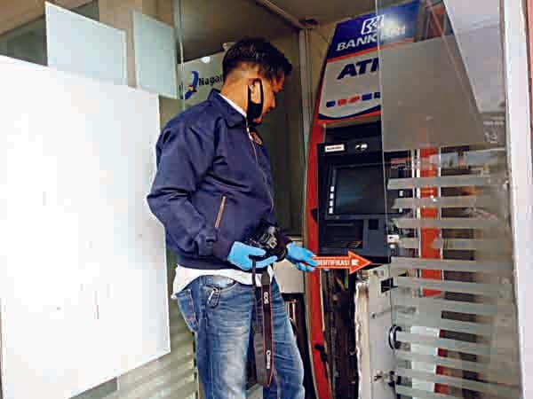ATM DIBOBOL— Petugas Satreskrim Polres Bukittinggi melakukan olah TKP di mesin ATM BRI yang dibobol maling.
