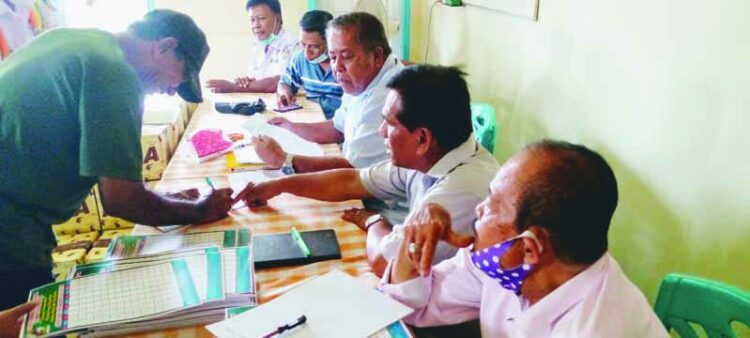 SAKSIKAN—Seorang KRK tandatangani pembagian uang daging disaksikan Ketua Koperbam Chandra, Nursal Uce M, SH, Usman Z, Paiman dan Sandi Ardi.