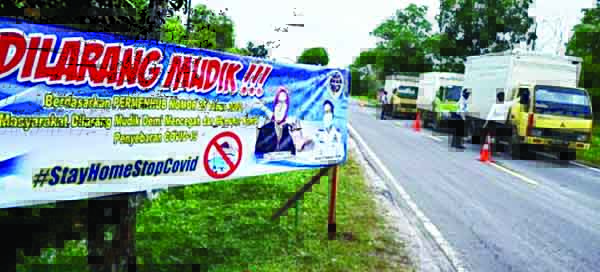 HALAU PEMUDIK— Petugas gabungan melakukan penjagaan di perbatasan untuk menghalau pemudik.