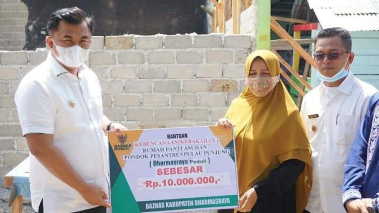 BANTUAN—Bupati Sutan Riska Tyanku Kerajaan saat menyerahkan bantuan Rp 10 Juta dan Beras kepada Pihak Pondok Pesantren Pembangunan Pulau Punjung  Dharmasraya.