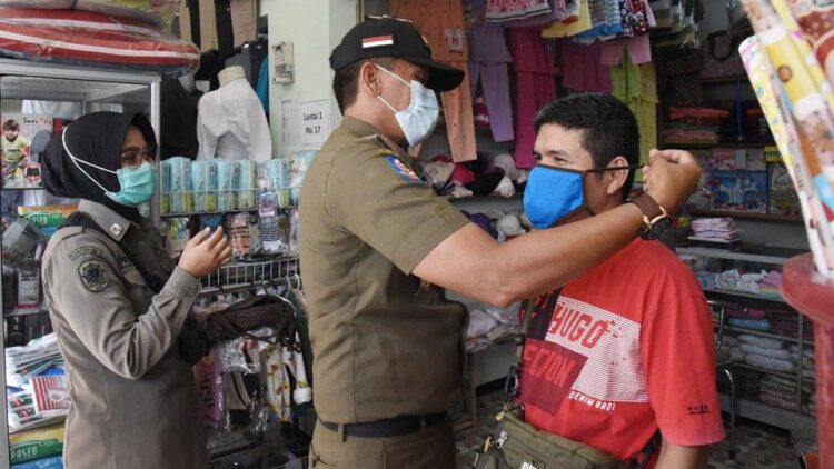 PAKAIKAN MASKER— Kepala Dinas Satpol PP dan Damkar Kota Pariaman Elfis Chandra memakaikan masker pada masyarakat.