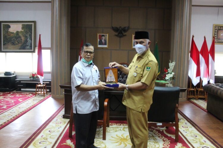 SERAHKAN—Sekum KONI Sumbar Irnaldi Samin memberikan plakat PB PON XX kepada Gubernur Sumbar Mahyeldi di ruang kerjanya, Senin (5/4).