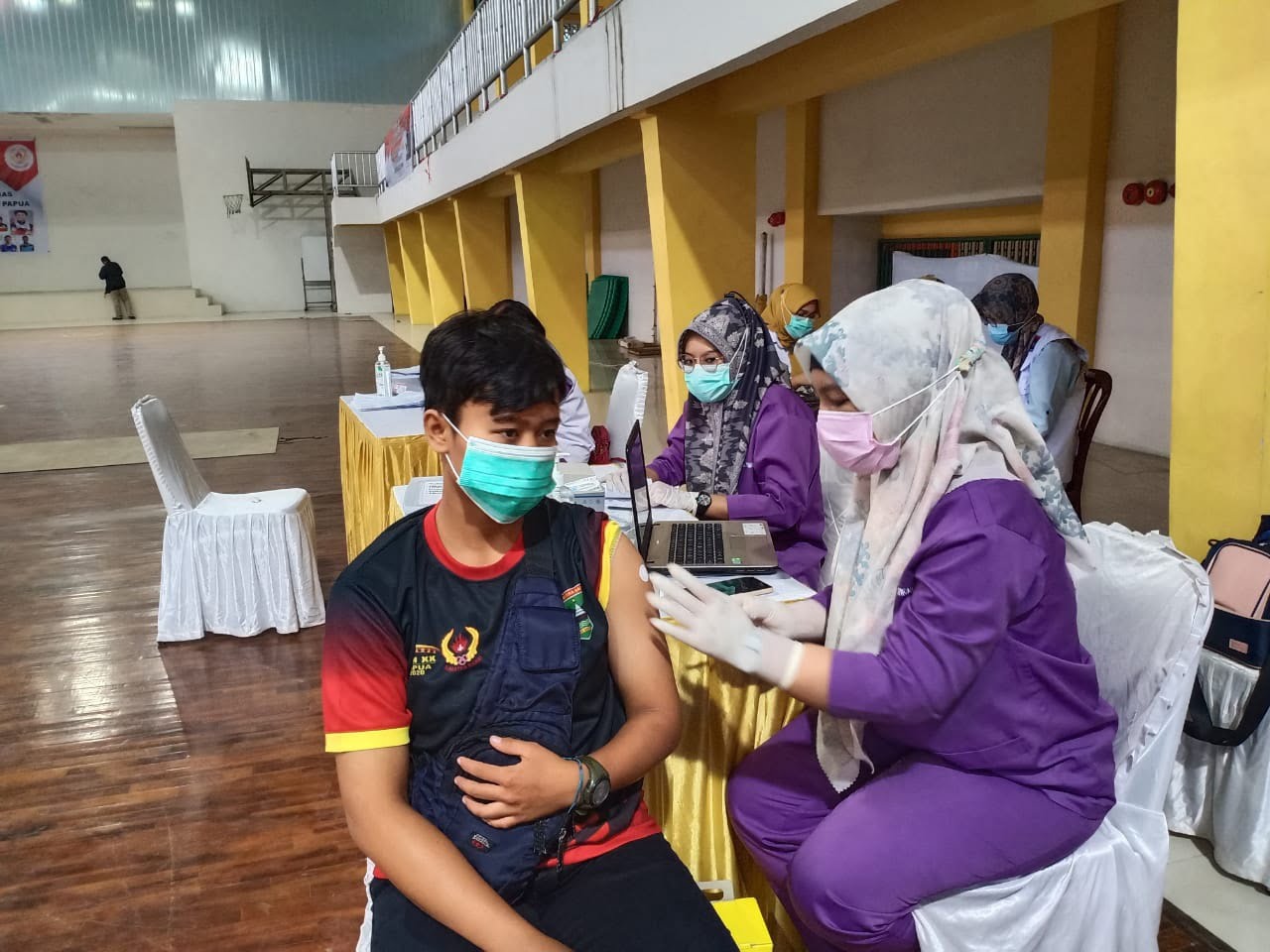 Slah seorang atlet PON Sumbar menjalani vaksinasi Covi 19 di gedung Sport Hall GOR AGus Salim Padang