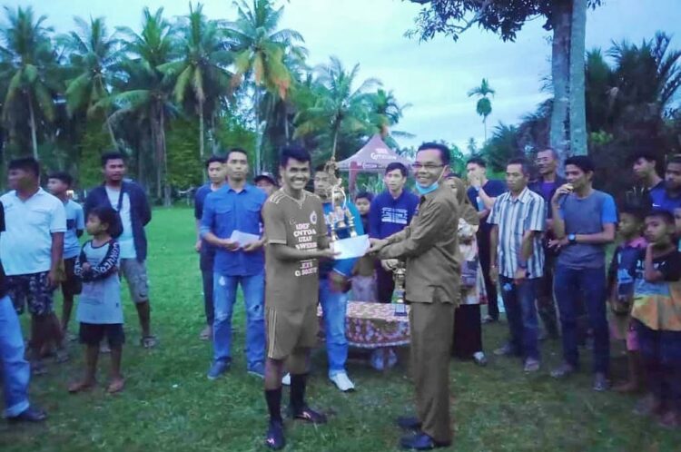 SERAHKAN--Lurah Campago Ipuah, Hendra Wirman menyerahkan trofi kepada Tim Futsal Annasiatoing FC yang menggondol juara Turnamen Futsal Karang Taruna (KT) Suluah Nagari IPPASS CUP II 2021.