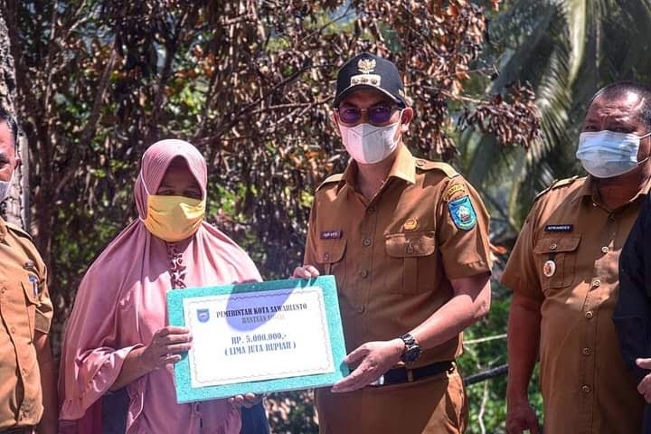 Baznas Bantu Korban Kebakaran 1 SALURKAN BANTUAN— Wali Kota Sawahlunto Deri Asta salurkan bantuan Rp 5 juta kepada Ermiwati korban kebakaran di Aia Dingin, Kecamatan Lembah Segar.