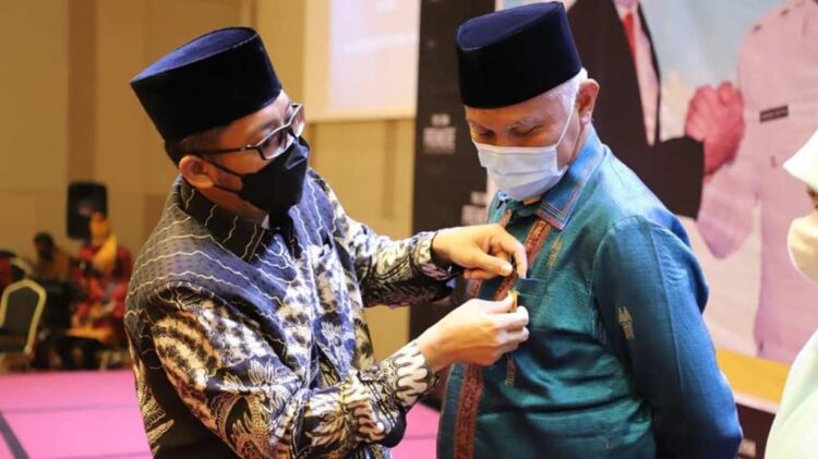 KENANG-KENANGAN— Wali Kota Padang Hendri Septa memberikan kenang-kenangan kepada Buya Mahyeldi dalam acara malam pisah sambut, Minggu (11/4).