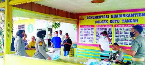 TERJARING OPERASI YUSTISI— Tim gabungan Pemko dan kepolisian memeriksa dan mendata belasan warga yang terjaring Operasi Yustisi, Selasa (18/5). Sebanyak 18 warga harus membayar denda Rp 100 ribu karena tak pakai masker.