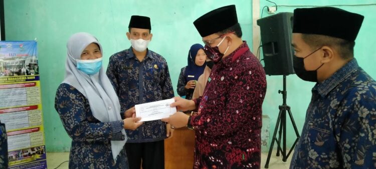 ZAKAT MAL— Kakankemenag Lima Puluh Kota H Naharudin menyerahkan zakat mal kepada muzakki untuk disalurkan kepada mustahik.