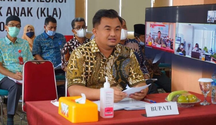 PAPARKAN— Bupati Dharmasraya, Sutan Riska Tuanku Kerajaan saat memaparkan sejumlah program KLA ke TIM Verifikator KPPPA RI secara daring dari Aula Lantai II Kantor Bupati Dharmasraya, Kamis (27/5).