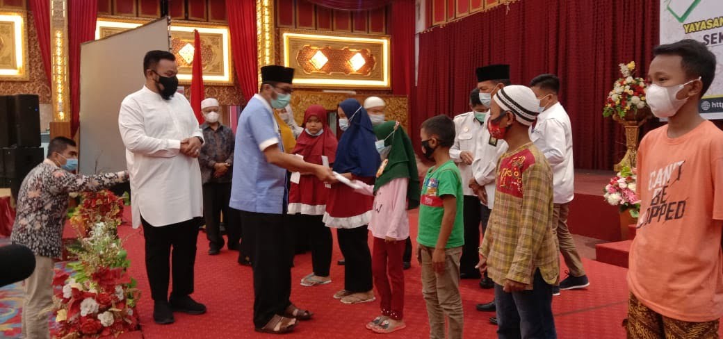 Walikota Padang Hendri Septa menyerahkan infak dan sadakah YPTK UPI Padangsecara simbolie kepad anak yatim.