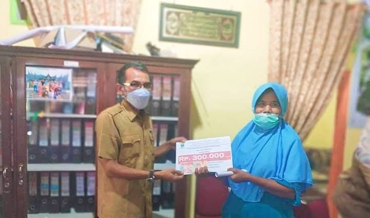 SERAHKAN BLT— Kasi Trantib Anesa Satria menyerahkan BLT kepada salah seorang warga.