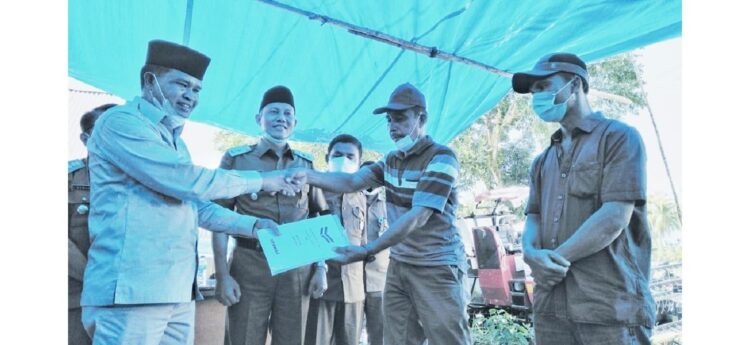 SERAHKAN—Anggota DPRD Provinsi Sumatera Barat Fraksi Gerindra, Khairuddin Simanjuntak saat menyerahkan alat sistem pertanian jenis Combine Harvester (Jarwo) kepada dua kelompok tani.